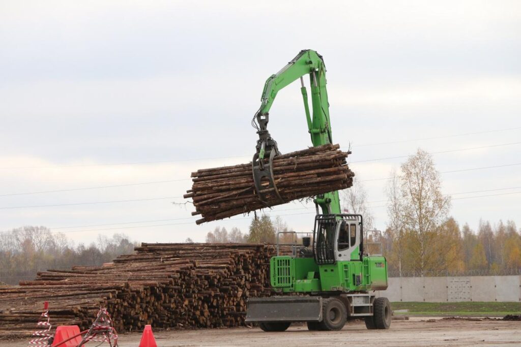 A SENNEBOGEN 735 pick & carry machine handles logs in the busy yard of the Taleon Terra oriented strand board plant in Torzhok, Russia.