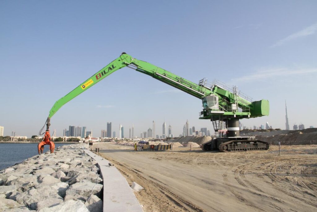 Reaching out to 115 ft. (35 m), the SENNEBOGEN 880 EQ precisely place rocks weighing up to 7 tons to construct a new seawall on the coast of Dubai.